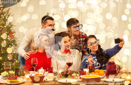 Image of friends taking selfie at christmas dinner