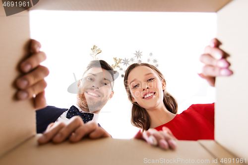 Image of happy couple opening christmas gift box