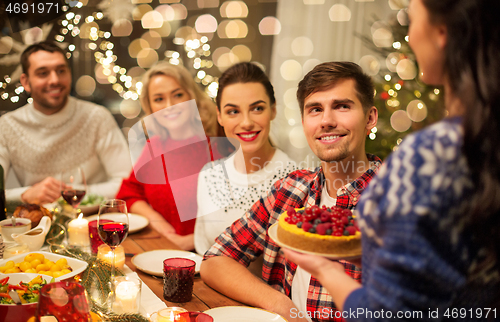 Image of happy friends having christmas dinner at home