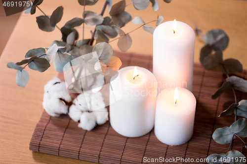 Image of candles and branches of eucalyptus on table