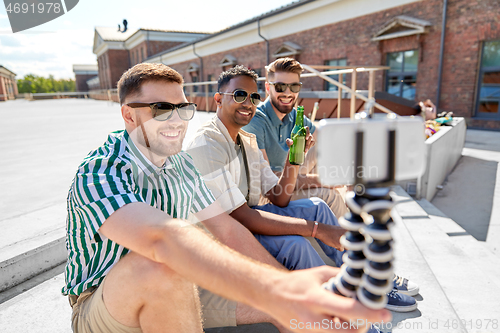 Image of men drinking beer and taking selfie by smartphone