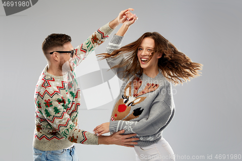 Image of couple dancing at christmas ugly sweaters party