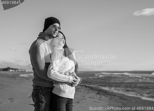 Image of Loving young couple on a beach at autumn sunny day