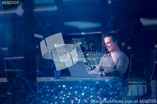 Image of man working on laptop in dark office