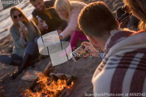 Image of Friends having fun at beach on autumn day