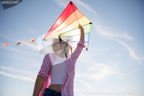 Image of Young Woman with kite at beach on autumn day