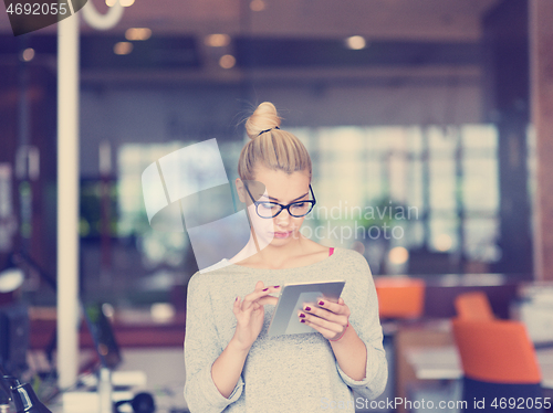 Image of woman working on digital tablet in night office