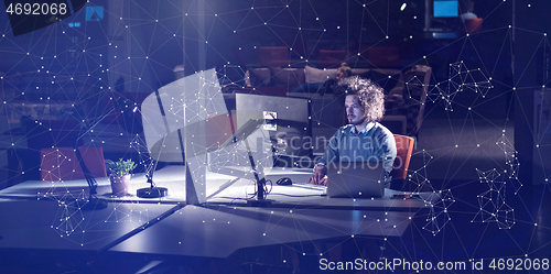 Image of man working on computer in dark office