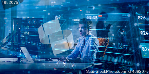 Image of man working on computer in dark office