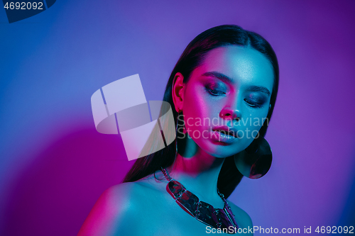 Image of High Fashion model in colorful bright neon lights posing at studio