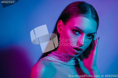 Image of High Fashion model in colorful bright neon lights posing at studio