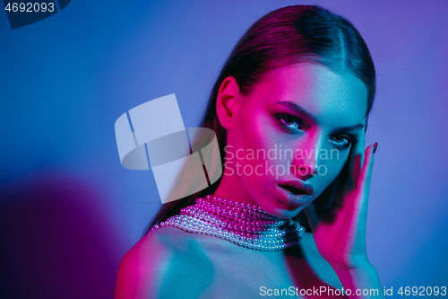 Image of High Fashion model in colorful bright neon lights posing at studio