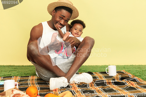 Image of Happy family having picnic at studio