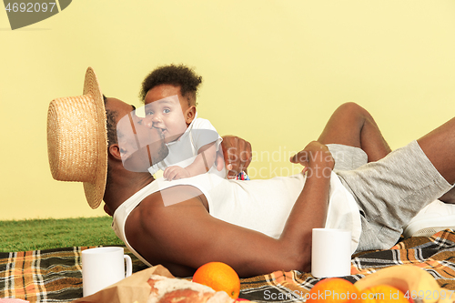 Image of Happy family having picnic at studio