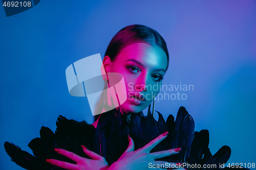 Image of High Fashion model in colorful bright neon lights posing at studio