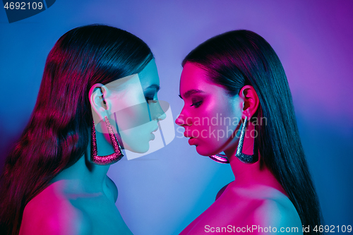 Image of High Fashion models in colorful bright neon lights posing at studio