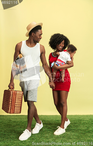 Image of Happy family having picnic at studio