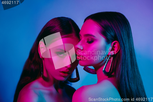 Image of High Fashion models in colorful bright neon lights posing at studio