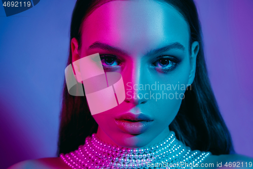 Image of High Fashion model in colorful bright neon lights posing at studio