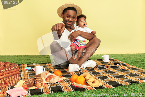 Image of Happy family having picnic at studio