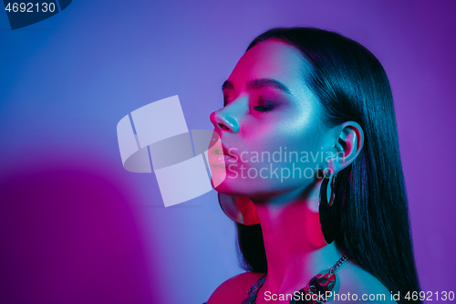 Image of High Fashion model in colorful bright neon lights posing at studio