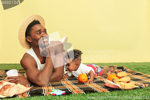 Image of Happy family having picnic at studio