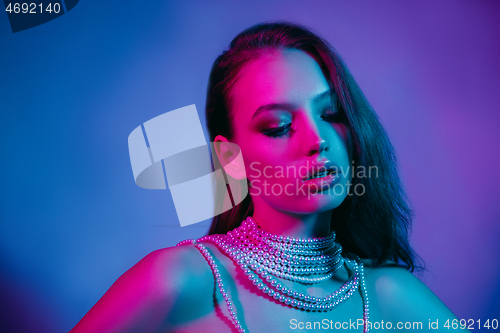 Image of High Fashion model in colorful bright neon lights posing at studio