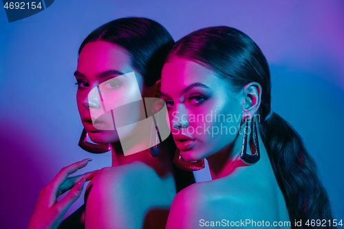 Image of High Fashion models in colorful bright neon lights posing at studio