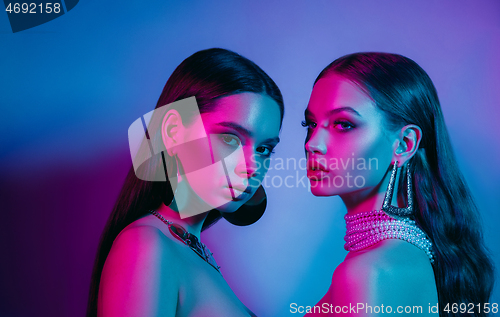 Image of High Fashion models in colorful bright neon lights posing at studio