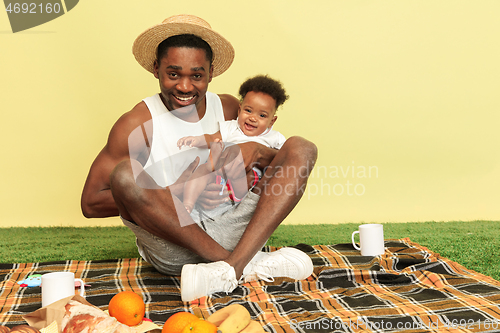 Image of Happy family having picnic at studio