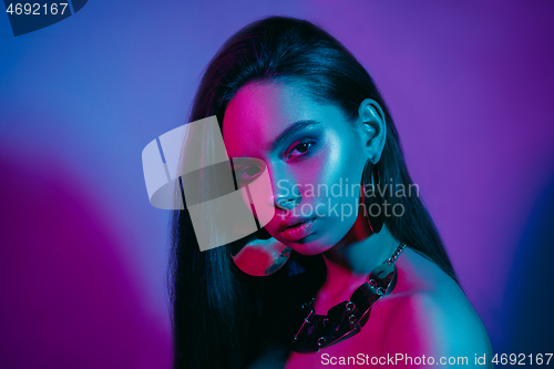 Image of High Fashion model in colorful bright neon lights posing at studio