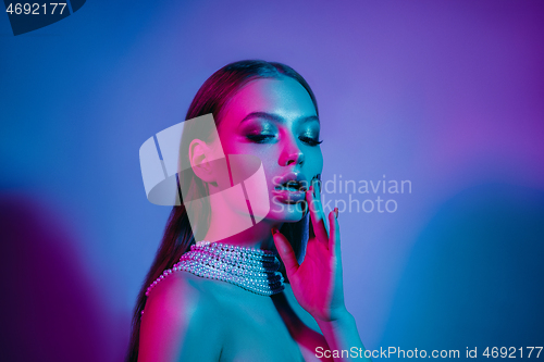 Image of High Fashion model in colorful bright neon lights posing at studio