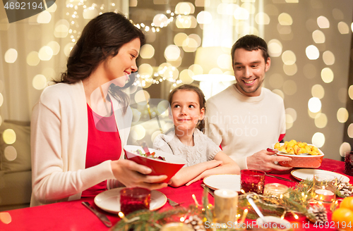 Image of happy family having christmas dinner at home