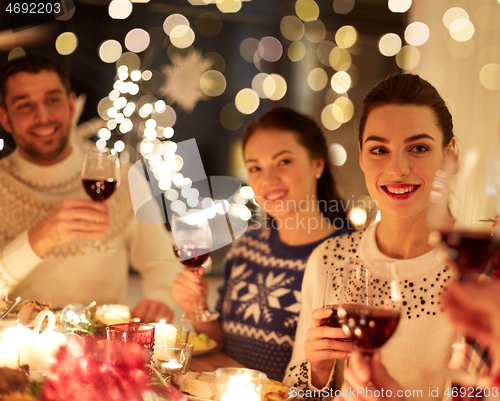 Image of happy friends celebrating christmas at home