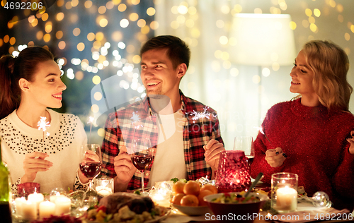 Image of happy friends celebrating christmas at home feast