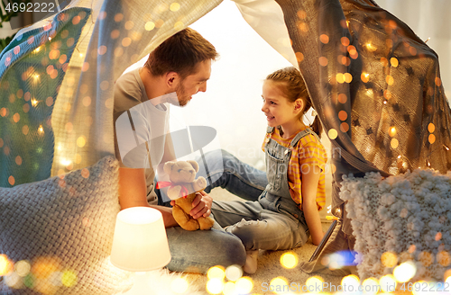 Image of happy family playing with toy in kids tent at home