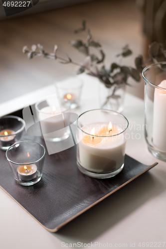 Image of burning fragrance candles on table at cozy home