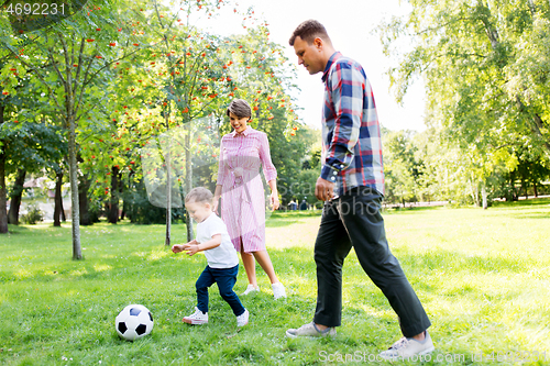 Image of happy family playing soccer at summer park