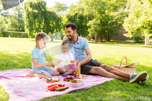 Image of happy family having picnic at summer park