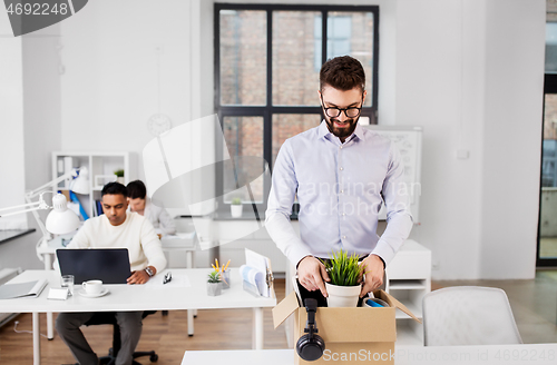 Image of happy male office worker with personal stuff