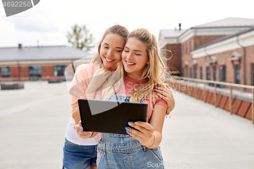 Image of teenage girls with tablet computer on roof top