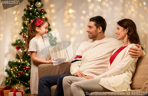 Image of happy family with christmas present at home