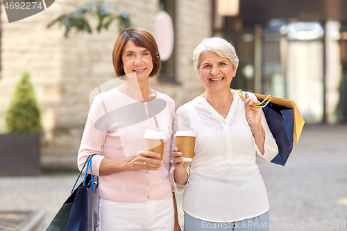 Image of senior women with shopping bags and coffee in city