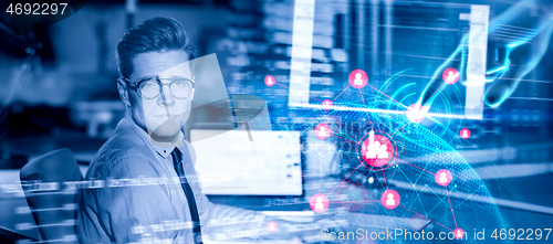 Image of man working on computer in dark office