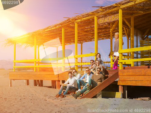 Image of Group of friends having fun on autumn day at beach