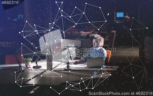 Image of man working on computer in dark office