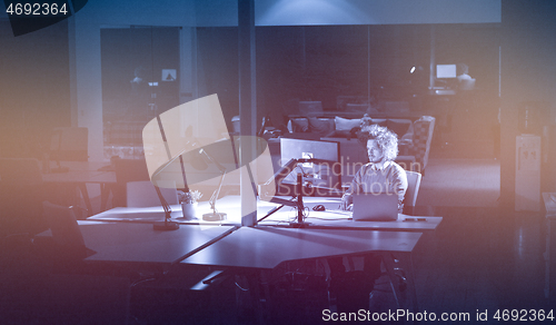 Image of man working on computer in dark office