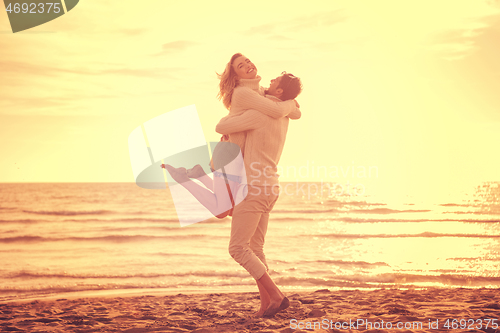 Image of Loving young couple on a beach at autumn sunny day