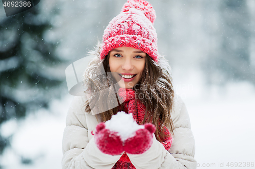 Image of portrait of young woman with snow in winter park