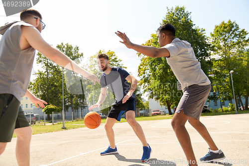 Image of group of male friends playing street basketball